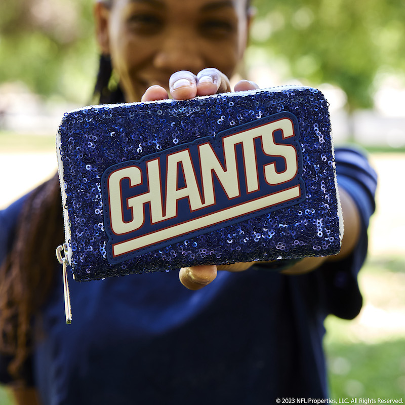 Image of woman holding the NFL New York Giants Sequin Wallet out to camera